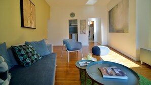 A modern living room with a sofa, armchairs, a coffee table, and artwork on the walls. - Apartment with cathedral view in the historical quarter  (Montpellier)