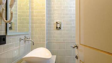 A bathroom with a white sink, a hairdryer, and a mirror.