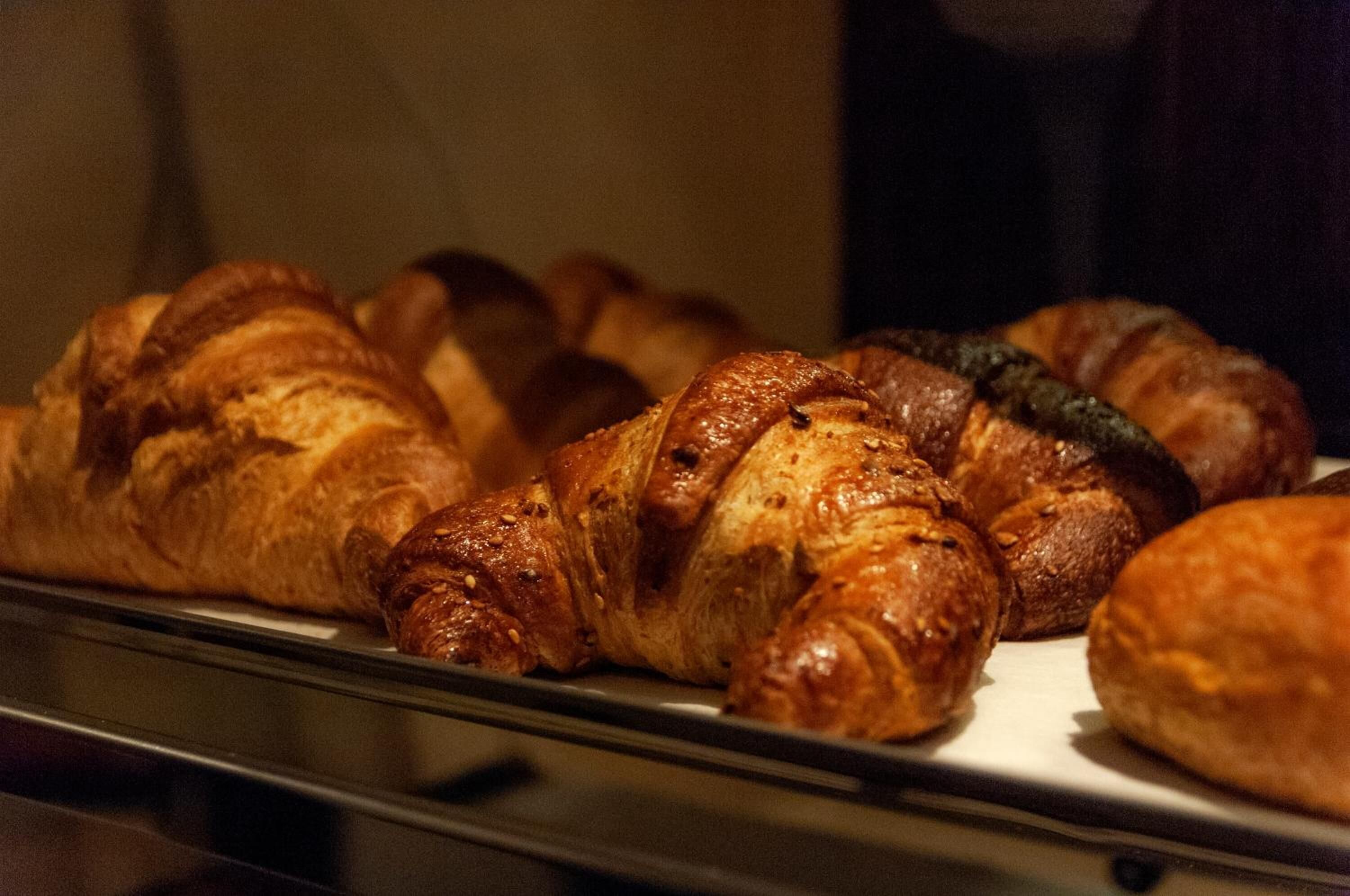 Eine Vitrine mit verschiedenen Backwaren, darunter Croissants und Brot.