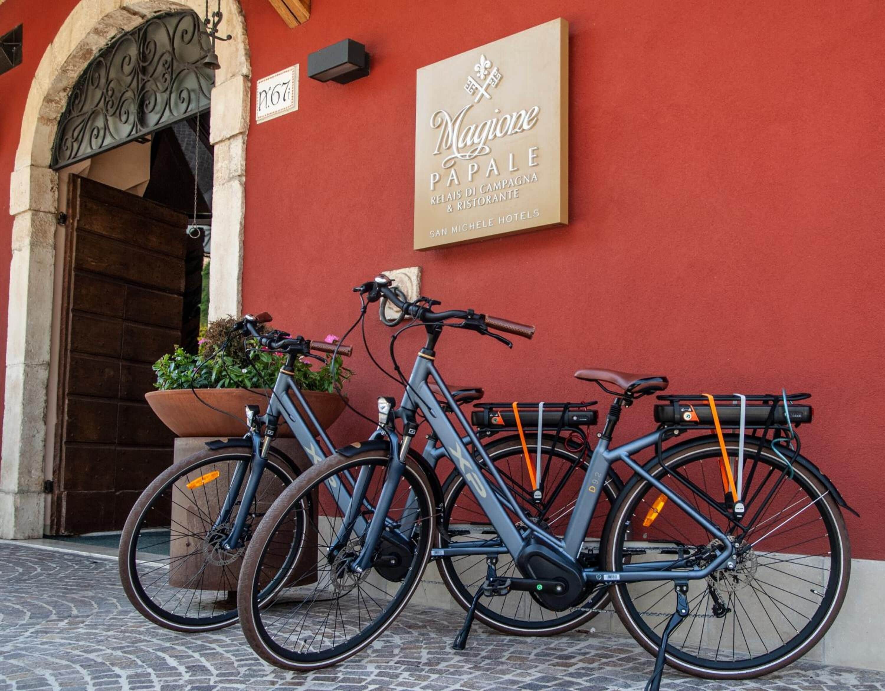 Un vélo est garé devant un bâtiment sur lequel on peut lire l’inscription « Magione PALE ».