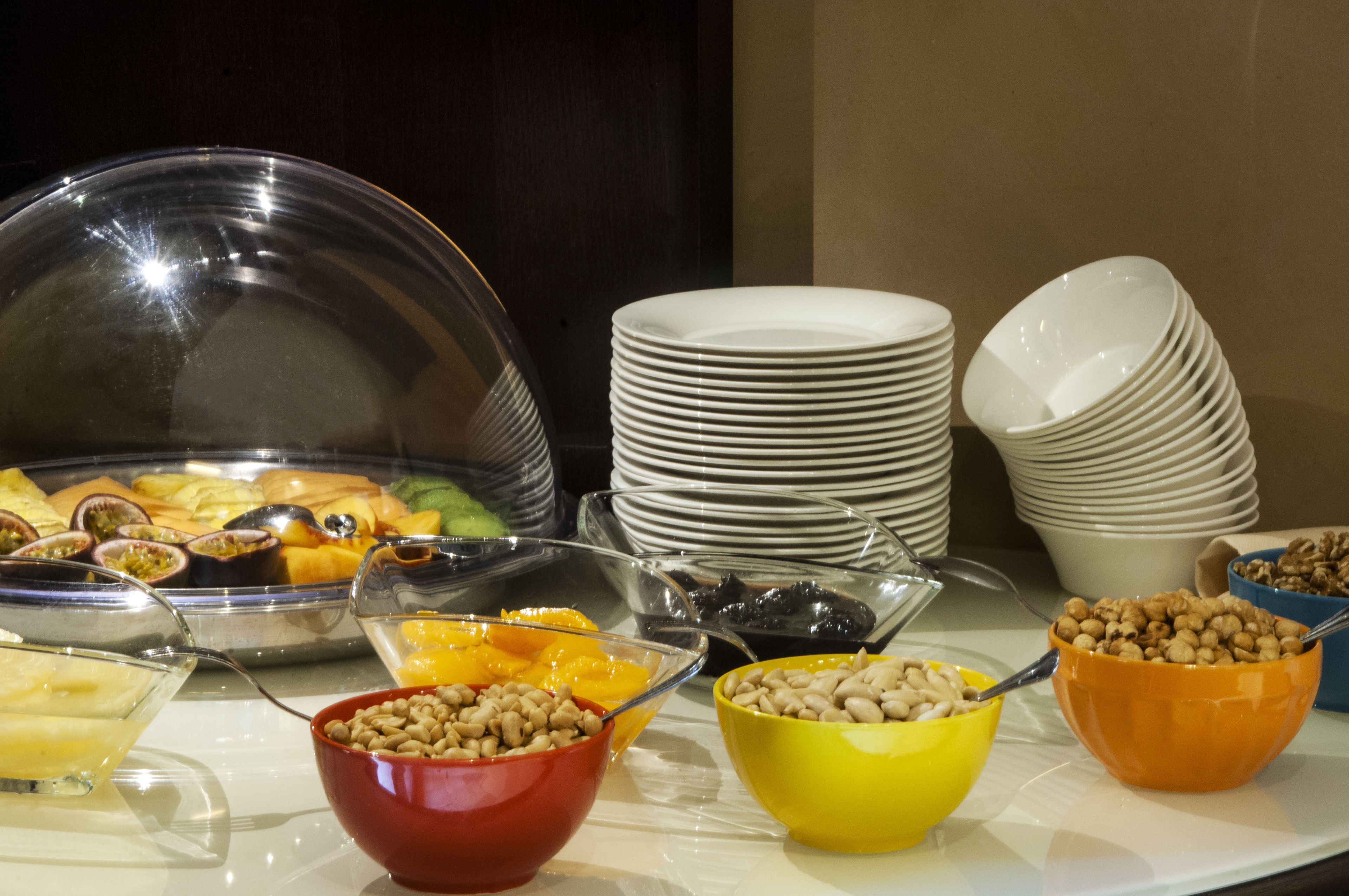 Un bufé con diversos alimentos y recipientes con frutos secos.