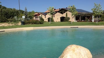 Una piscina al aire libre de temporada, sillones reclinables de piscina