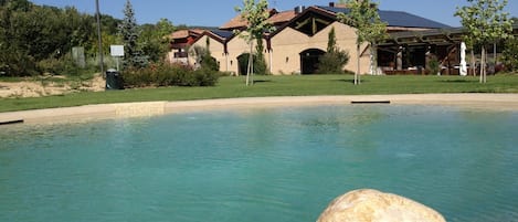 Una piscina al aire libre, sillones reclinables de piscina