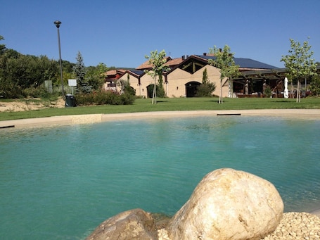 Una piscina al aire libre de temporada, sillones reclinables de piscina
