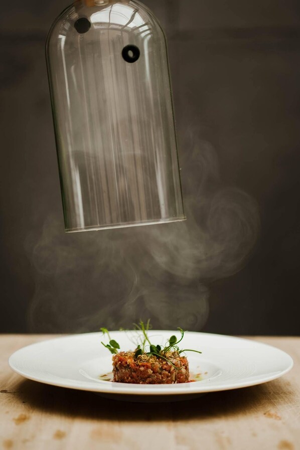 Un plato de comida con un objeto de vidrio transparente encima.