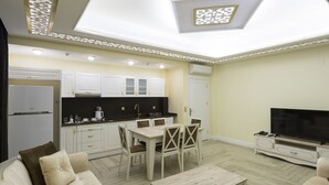Una sala de estar moderna con comedor, cocina y televisor.