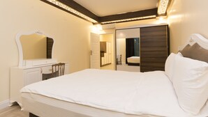 Un dormitorio con cama, cómoda, espejo y armario.