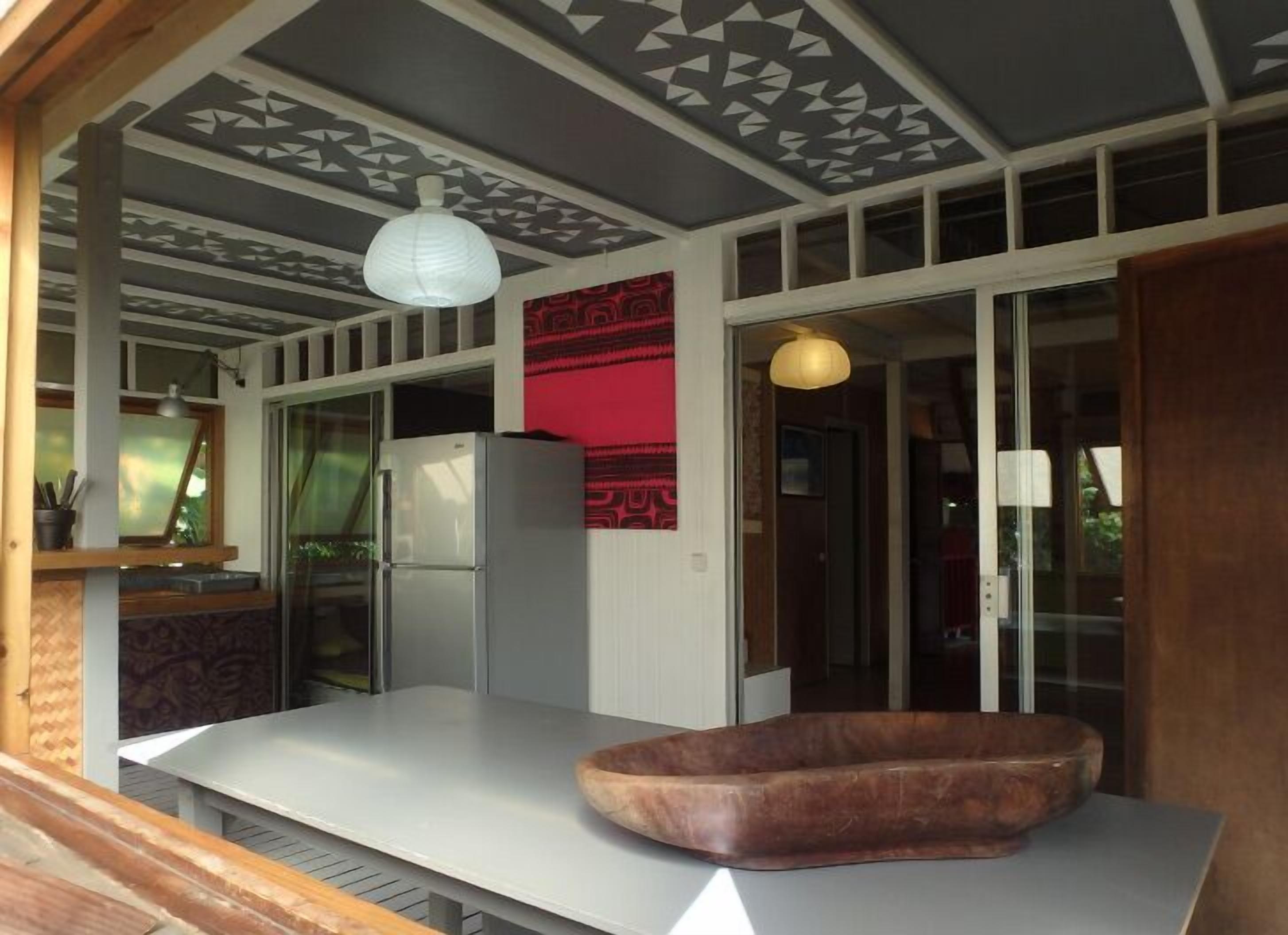 Una cocina moderna con encimera blanca, un refrigerador y un cuenco de madera.