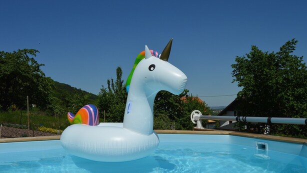 Une piscine avec une grande bouée en forme de licorne gonflable.