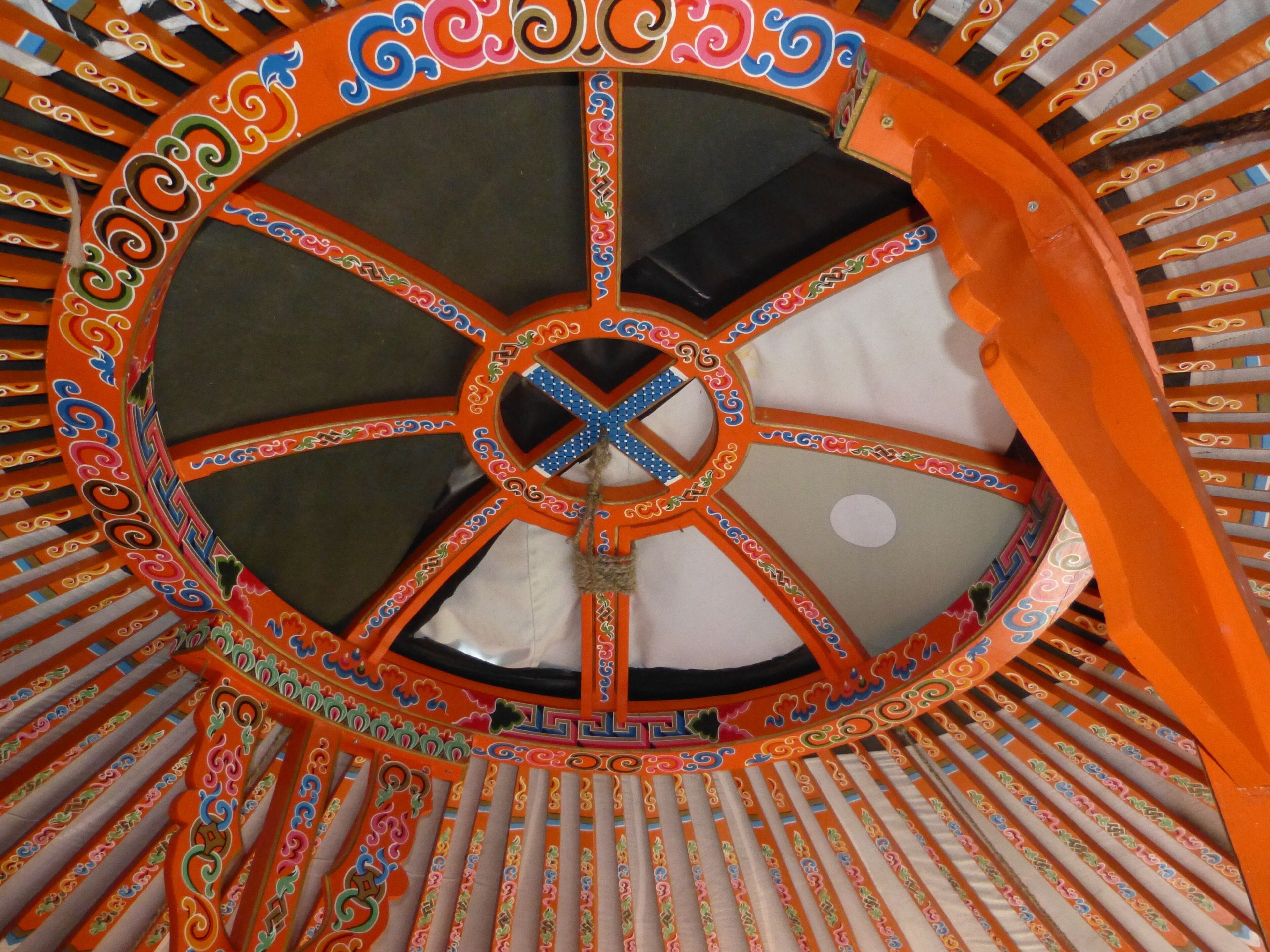Un techo circular y ornamentado con una ventana central y diseños intrincados.