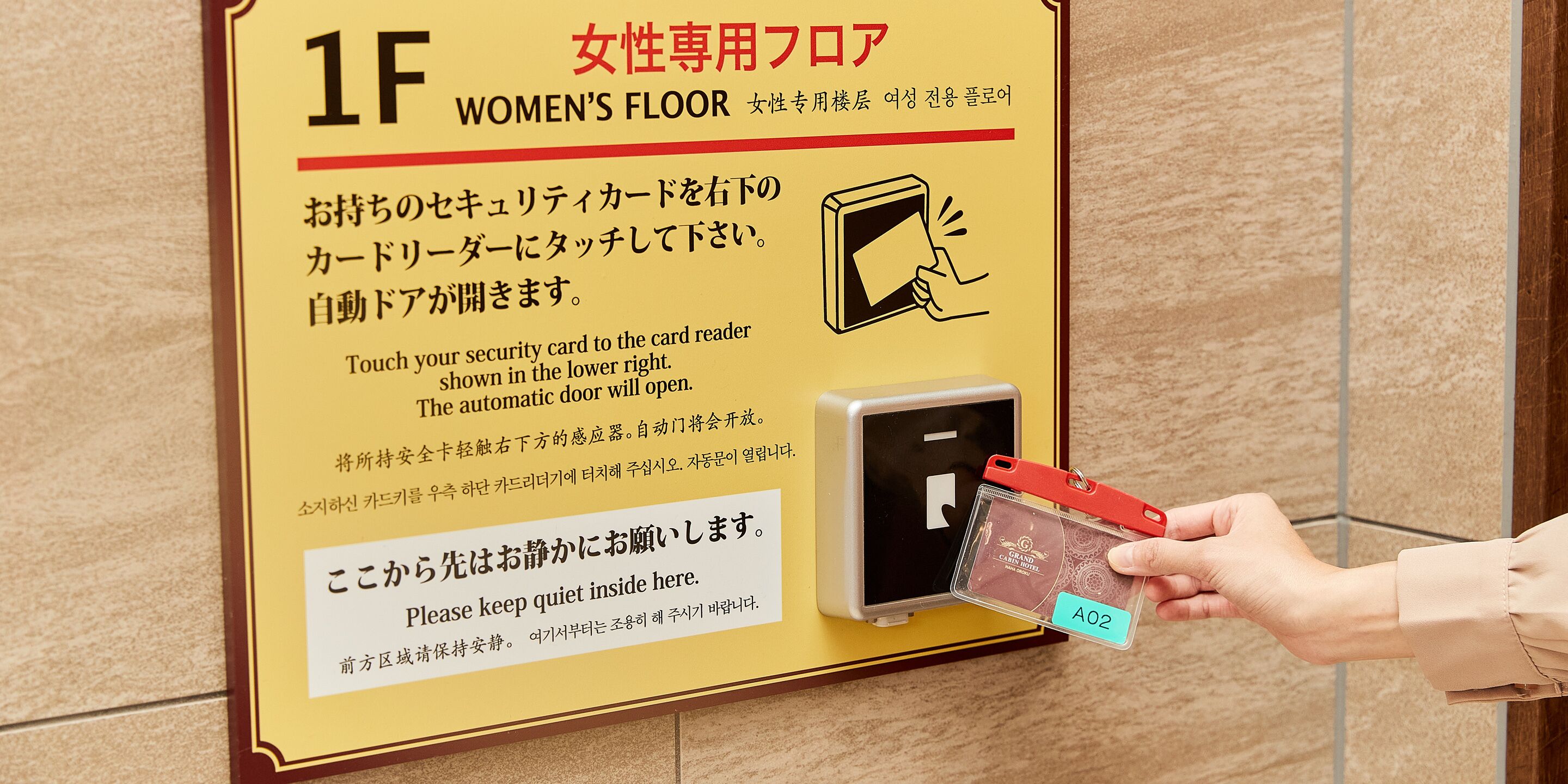 Un lecteur de carte de sécurité pour l’accès à un étage réservé aux femmes, avec des instructions en japonais et en anglais.