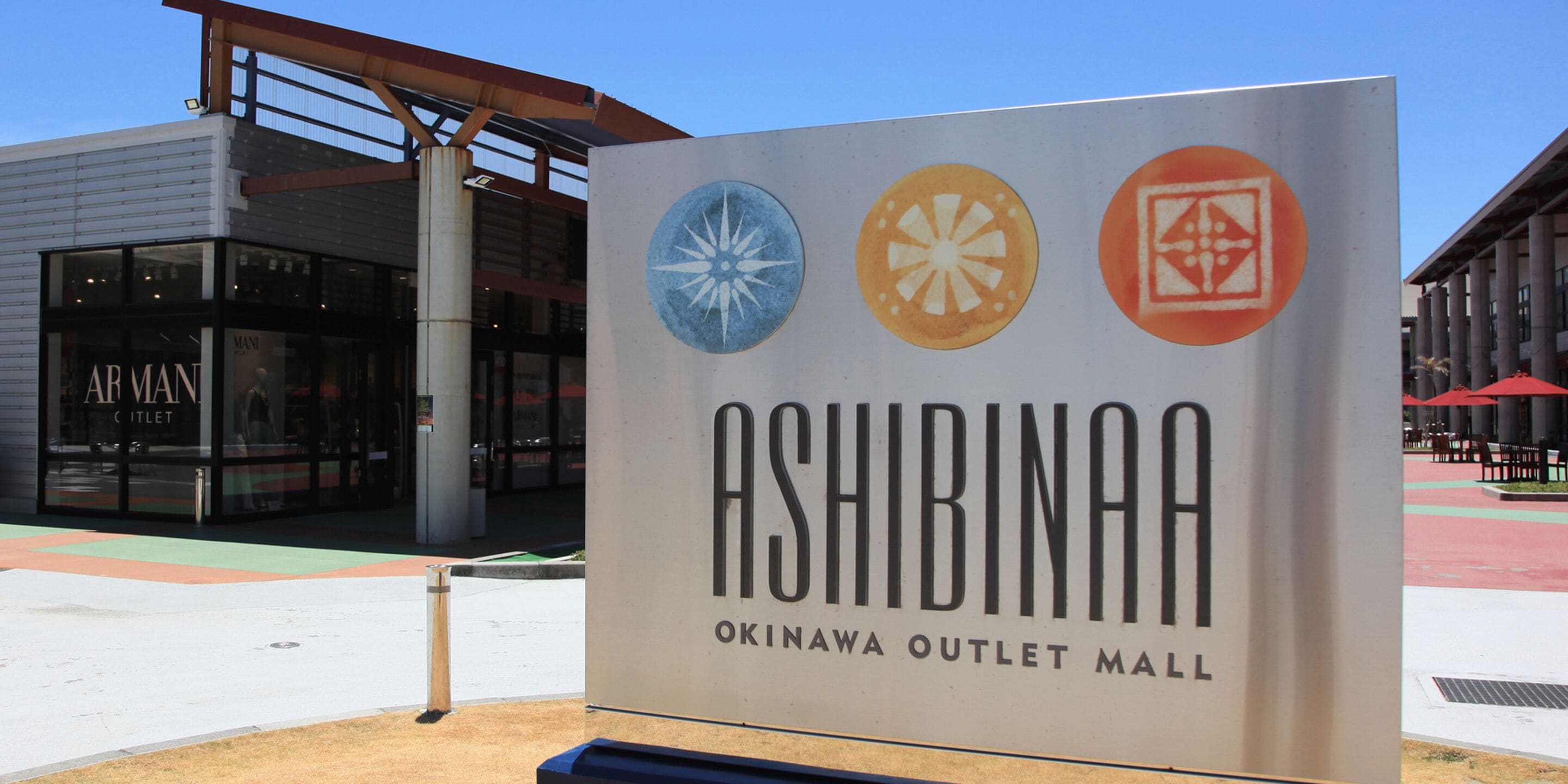 A sign for Ashibina Outlet Mall with three circular logos.