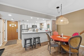 A modern kitchen with white cabinets, stainless steel appliances, and a central island with stools. - Location, Location, Location... Walk to everything Park City (Park City)