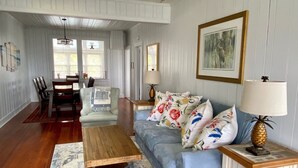 A spacious living room with a ceiling fan, a dining area with a table and chairs, and a large window providing natural light. - Ocean views everywhere! / Beach access in front of house! /close to restaurants. (Isle of Palms)
