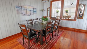 A dining room with a wooden table, six chairs, a red patterned rug, and a large window with blinds. - Ocean views everywhere! / Beach access in front of house! /close to restaurants. (Isle of Palms)