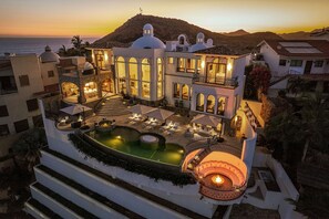 A luxurious resort with a swimming pool, outdoor seating, and a scenic mountain view. - Casa Rio de Luna: 7BR Ocean-View Villa with Pool, Rancho Cerro Colorado (Los Cabos)