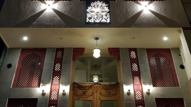 A multi-story building with illuminated windows and a central sign. - Prem Niwas Boutique Hotel (Jaipur)