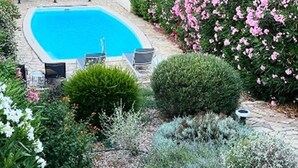 A swimming pool surrounded by lush greenery and flowering plants. - 2026 Comfort rental private heated pool 2 bedrooms air conditioning (Porto-Vecchio)