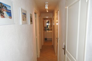Stylish hallway with framed artwork and a door leading to another room.