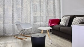 A modern living room with a grey sofa, white rocking chair, and a small round table. - CONTEMPORARY APARTMENT NICE HYPER CENTER 2 MINUTES BEACHES (Nice)