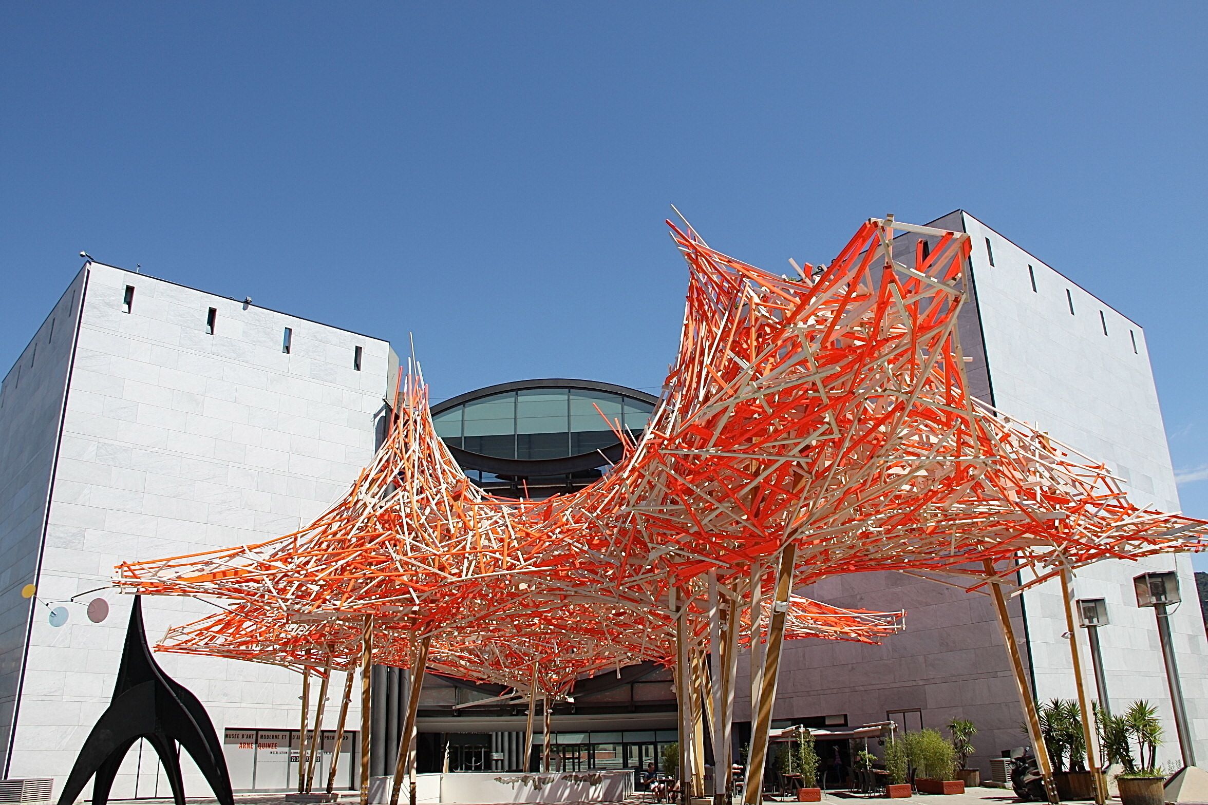 Un bâtiment moderne doté d’une structure de marquise orange distinctive à l’avant.