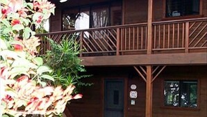 Een tweelaags houten gebouw met balkon, een deur en een bordje dat een rookruimte aangeeft.