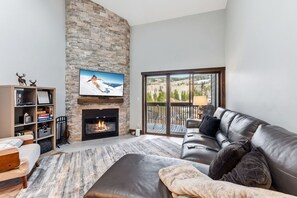 A living room with a fireplace, a sofa, a television, and a bookshelf. - Frisco Gem • Mountain Views • Clubhouse w/ Pool + 4 Hot Tubs (Frisco)