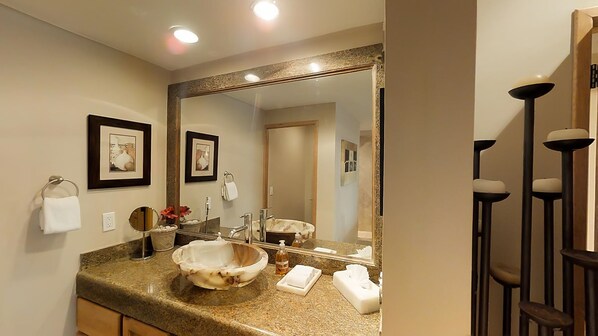 A bathroom with a granite countertop, a large mirror, a sink with a bowl, and framed pictures on the wall. - one block to medano beach , 2 blocks to the Cabo Marina & Downtown Cabo (Cabo San Lucas)