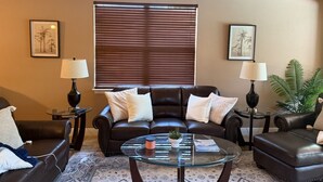 A living room with a brown leather sofa, two armchairs, a glass coffee table, and two lamps. - Luxurious Naples Florida Villa! Close to Vanderbilt Beach! ☀️🌴🌅 🌴 (Naples)