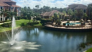 Ein Resort mit Schwimmbad, Springbrunnen und gepflegtem Rasen.
