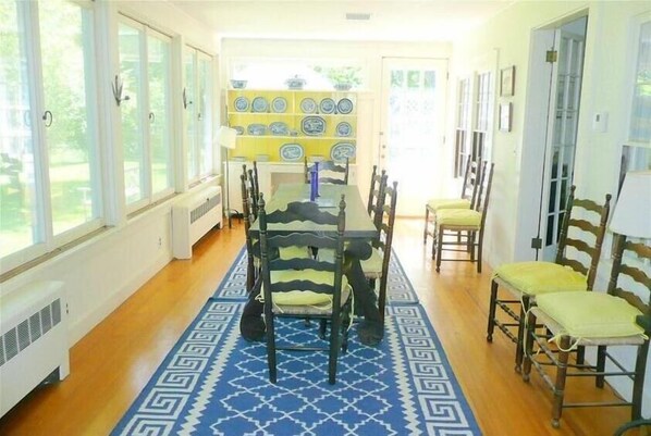 A dining area with a table, chairs, and a patterned rug. - Beautiful Seaside Home with Sweeping Views - Weekly Discounts Available! (Mt Desert)