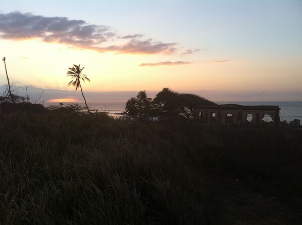 A coastal sunset with palm trees and a historical structure. - Spacious, attractively decorated 2 BR 1bath gated Apt, 4 Mins to Jobos Beach (Isabela)