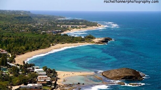 A coastal view with a beach, ocean, and buildings. - Spacious, attractively decorated 2 BR 1bath gated Apt, 4 Mins to Jobos Beach (Isabela)
