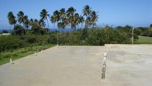 A concrete plaza with palm trees and a clear sky. - Spacious, attractively decorated 2 BR 1bath gated Apt, 4 Mins to Jobos Beach (Isabela)