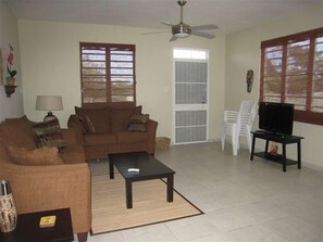 Relax in this cozy living space with a sofa, coffee table, and TV on a stand.