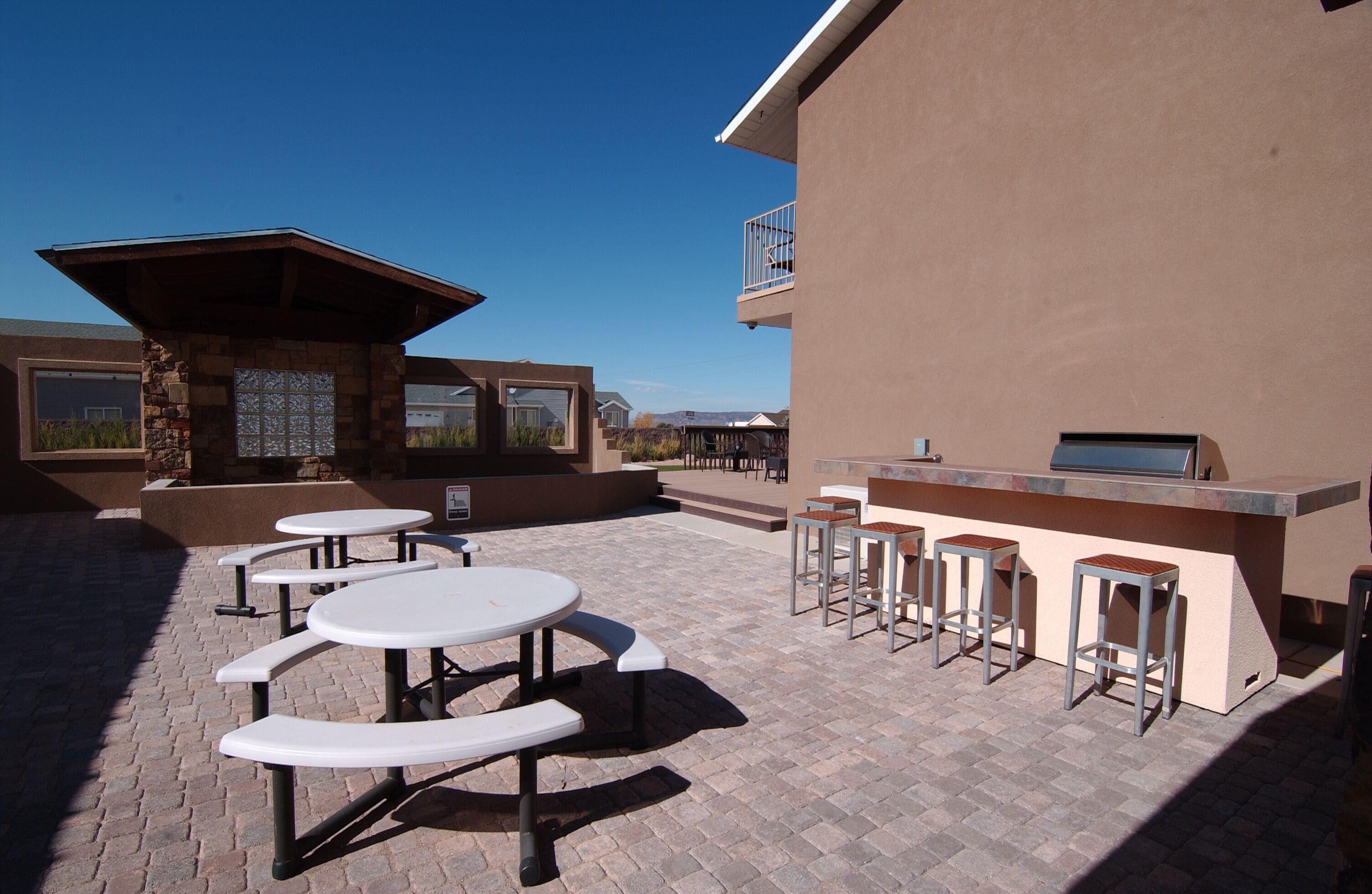 Un patio al aire libre con mesas de picnic y una zona de bar.