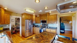 A kitchen with wooden cabinets, stainless steel appliances, granite countertops, and a built-in microwave. - Tacit Shadow "Aviator", Private Bedroom at base of Brian Head Mountain, WiFi (Parowan)