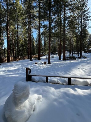 A snow-covered forest with a wooden bench and a snowman. - Meadow Drive Home In Beautiful Lake Tahoe Nevada (Stateline)