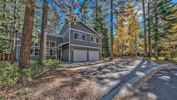 A modern two-story house with a garage, surrounded by tall pine trees and a clear sky. - Meadow Drive Home In Beautiful Lake Tahoe Nevada (Stateline)