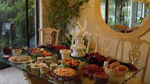 A glass-top dining table with various food items and a decorative white sculpture. - Green Vistas on the Tenth Tee is a one story end unit with wall to wall windows  (Palm Desert)