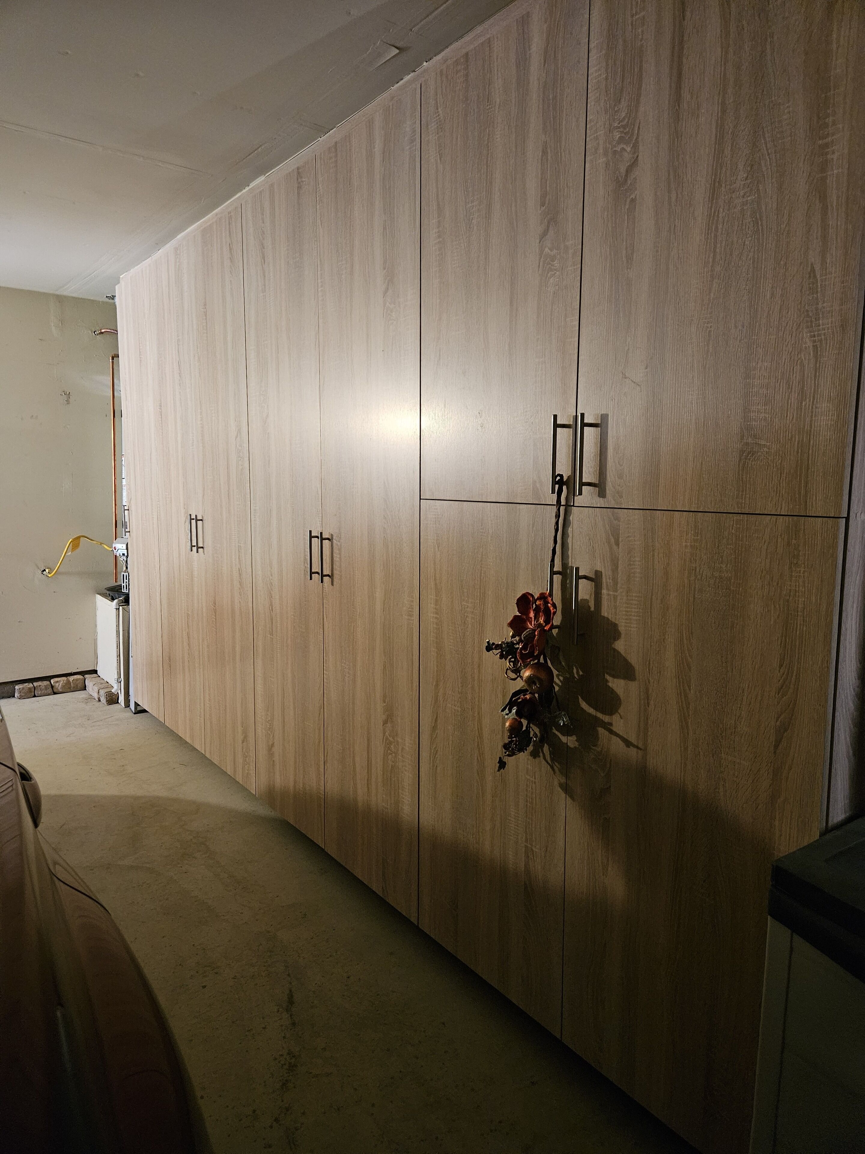 Une pièce comprenant une grande armoire en bois, une petite table et un objet décoratif accroché au mur.