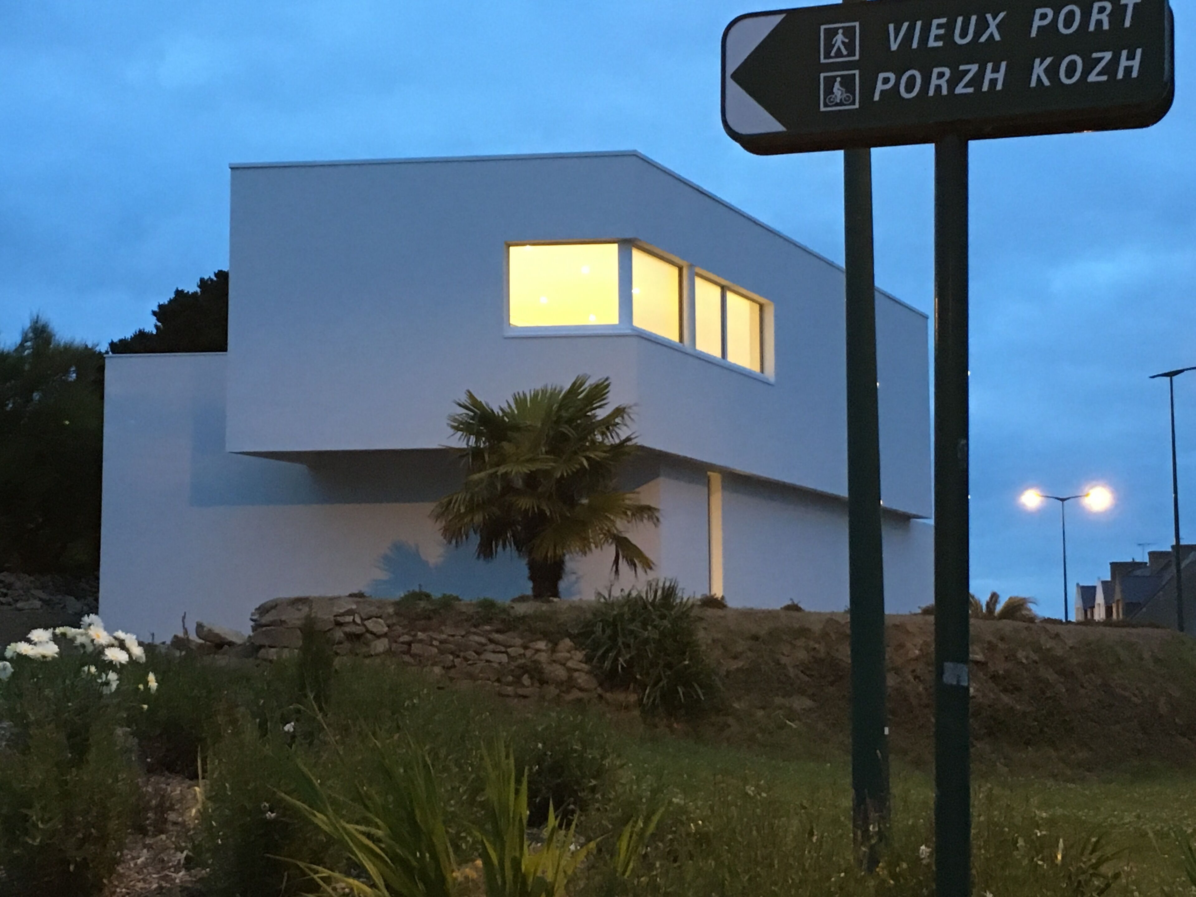 Un bâtiment moderne avec une enseigne indiquant les directions vers le Vieux-Port et Porzh Kozh.