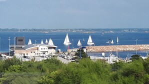 Une ville côtière dotée d’un port de plaisance, de bâtiments et d’une digue rocheuse.