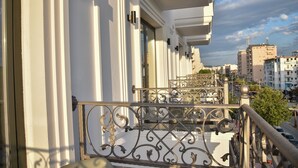 A balcony with ornate metal railings, a white building facade, and a view of the cityscape in the background. - Dolanit Hotels Lubjana (Durrës)