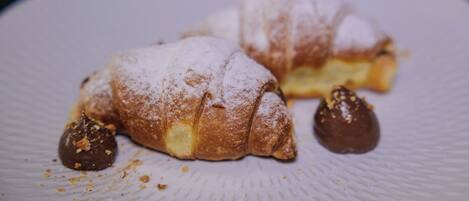 Two pastries on a textured white plate.