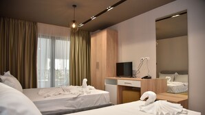 A hotel room with two beds, a desk with a flat-screen TV, a mirror, and a window with curtains. - Dolanit Hotels Lubjana (Durrës)