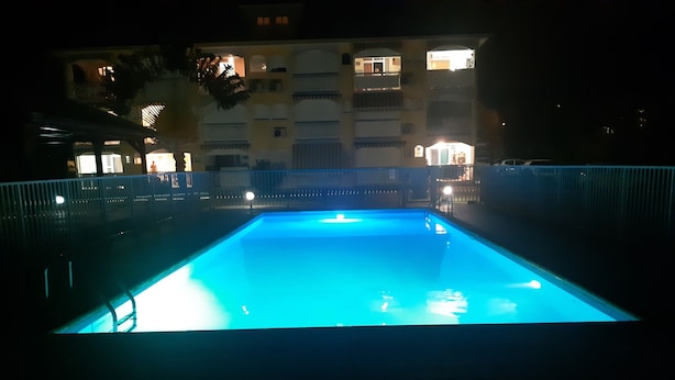 A swimming pool at night with a building in the background. - Charming BOUNTY studio, swimming pool and beaches 2 minutes walk (Sainte-Luce)
