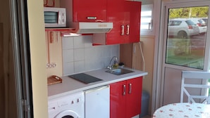 A compact kitchen with a microwave, sink, and washing machine. - Charming BOUNTY studio, swimming pool and beaches 2 minutes walk (Sainte-Luce)