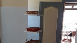 A bathroom with two sinks, a mirror, and a shelf with baskets. - Charming BOUNTY studio, swimming pool and beaches 2 minutes walk (Sainte-Luce)