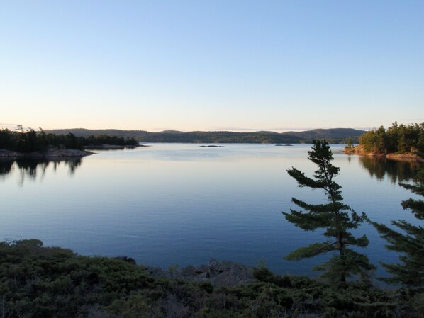 A calm lake surrounded by forested hills.